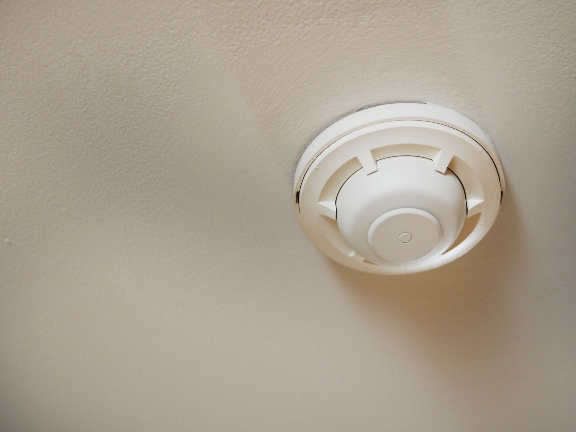 Ceiling-mounted smoke detector in home for residential fire protection services and safety.