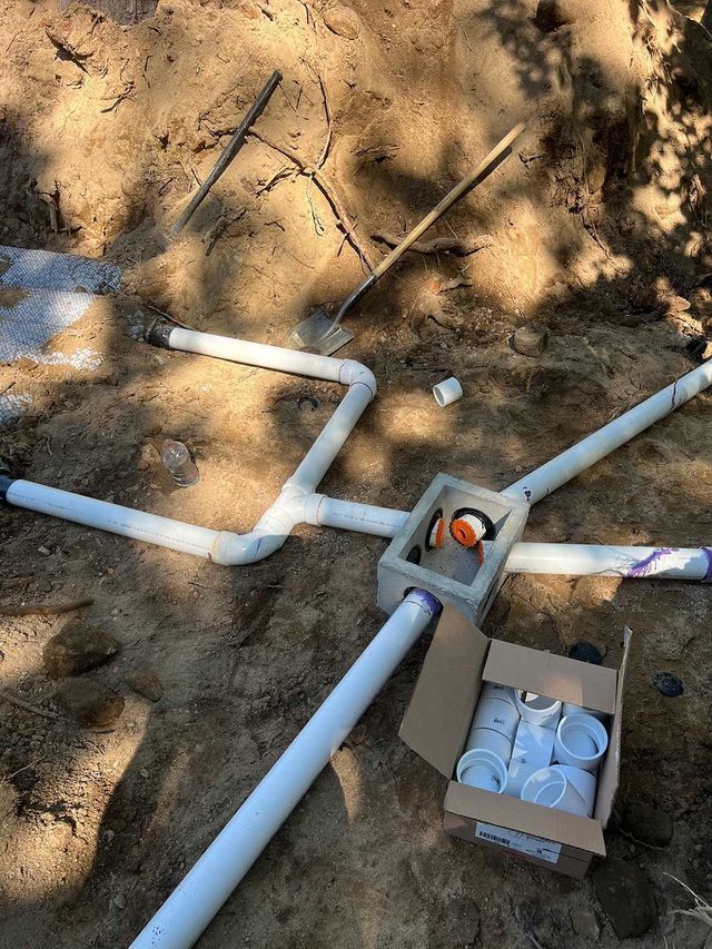 A box of pvc pipes is sitting on the ground next to a box of pvc pipes.