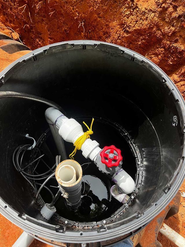 A black container with a red valve in the middle of it.