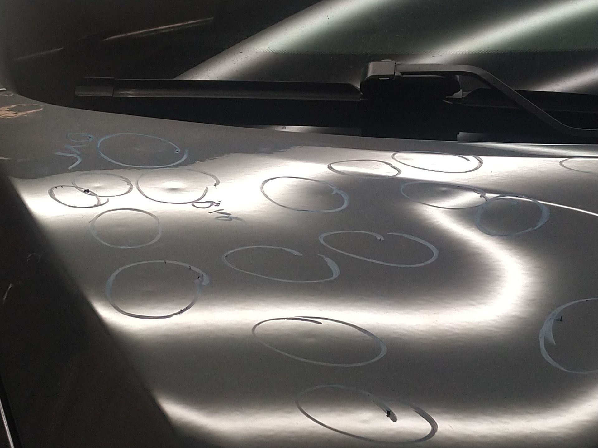 A close up of a car hood with a lot of holes in it.