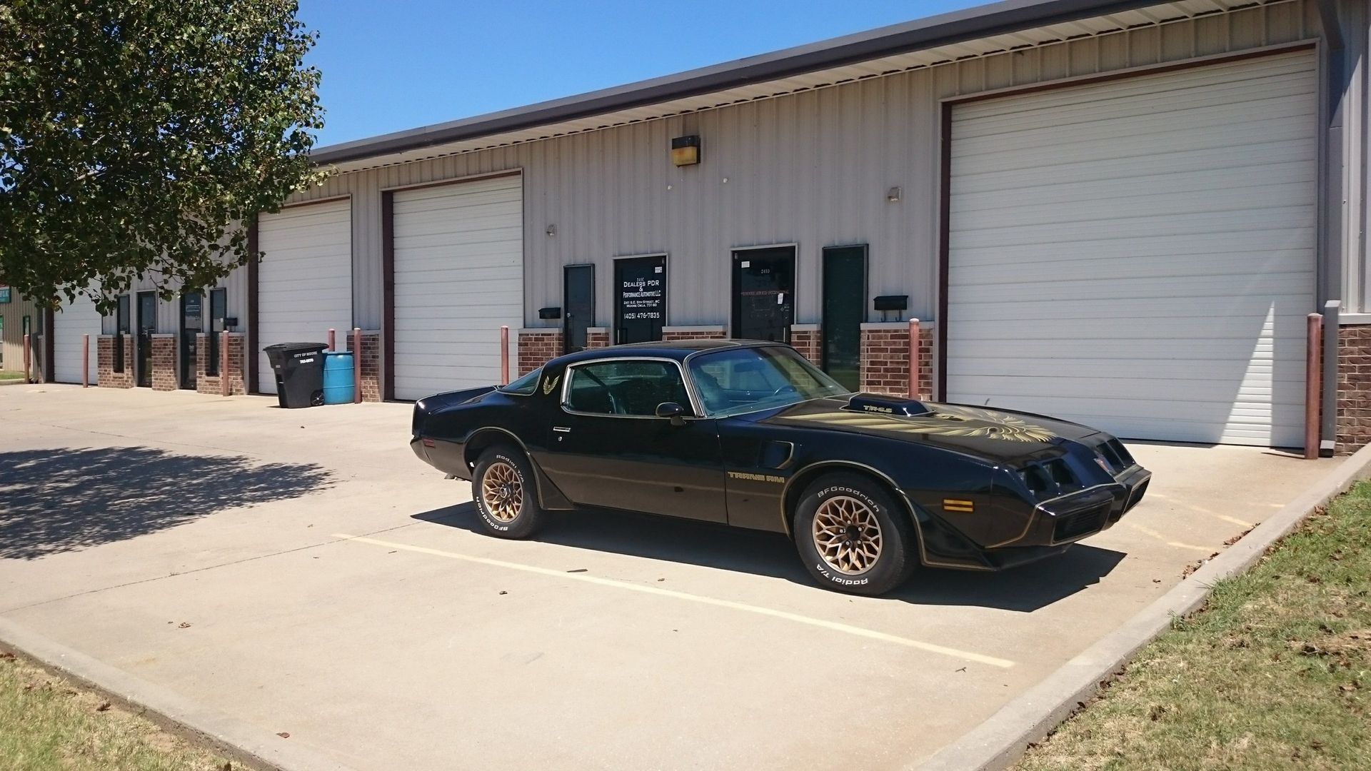 A black car is parked in front of a garage
