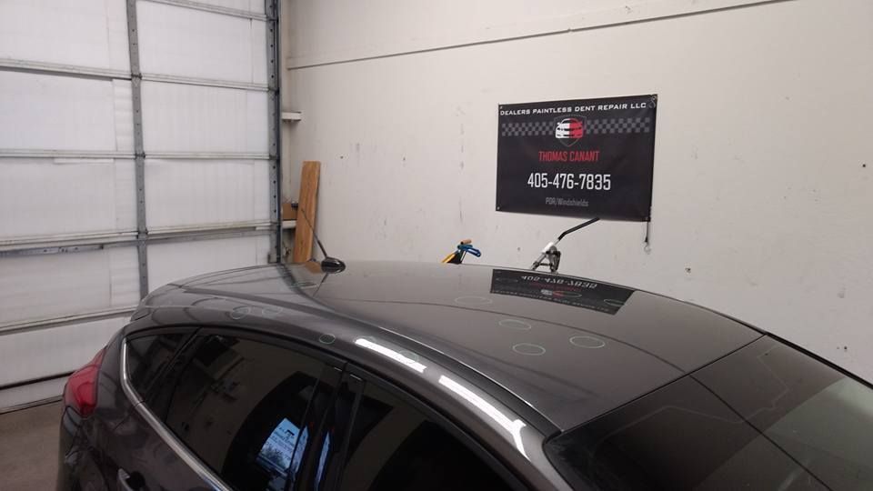 A car is parked in a garage next to a sign