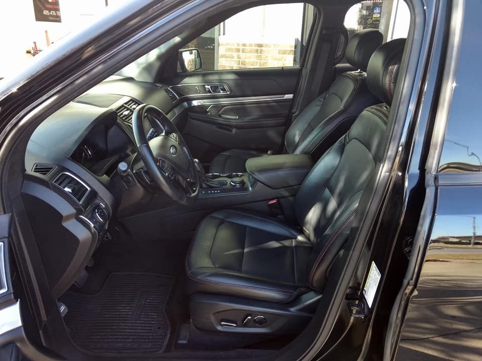 The inside of a black car with the door open