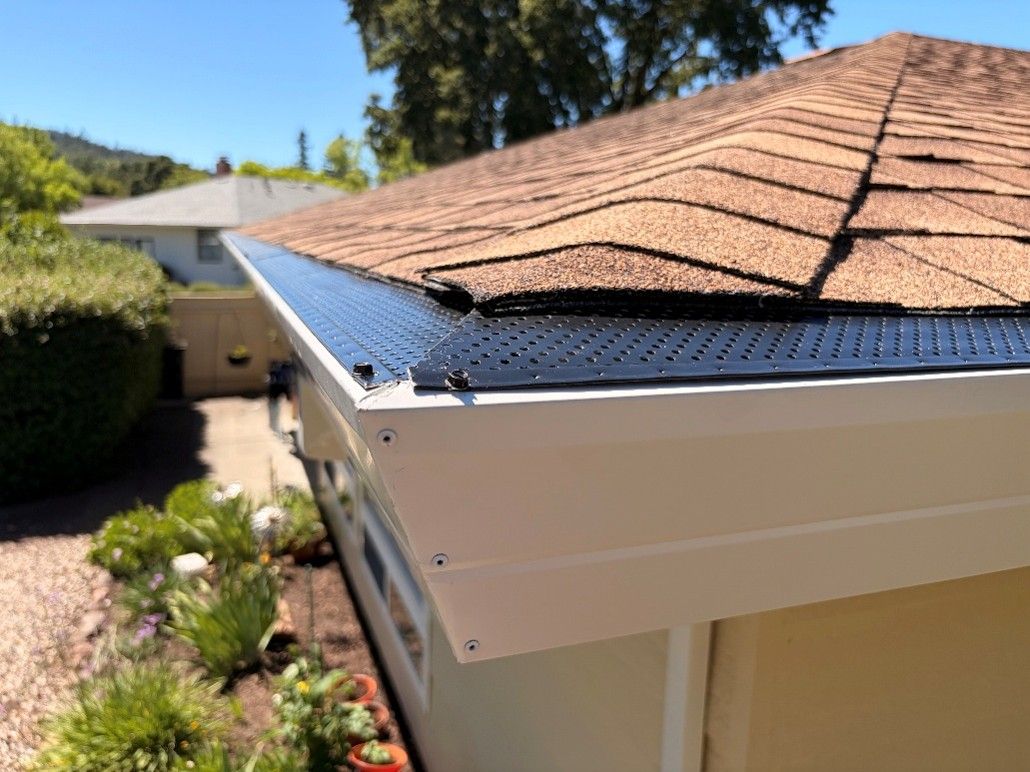 Seamless gutter with perforated leaf guard installed on asphalt shingle roof California