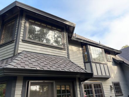 Two-story home with black gutters and a shingle roof.