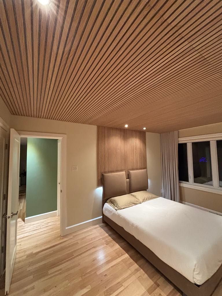 Une chambre avec un lit et un plafond en bois.