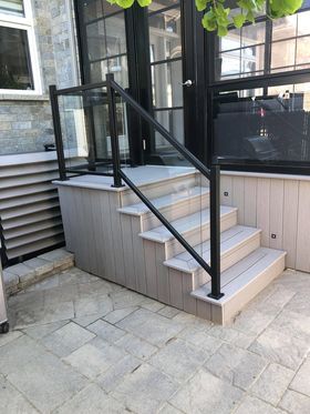 Un ensemble d'escaliers menant à une terrasse avec une balustrade en verre.