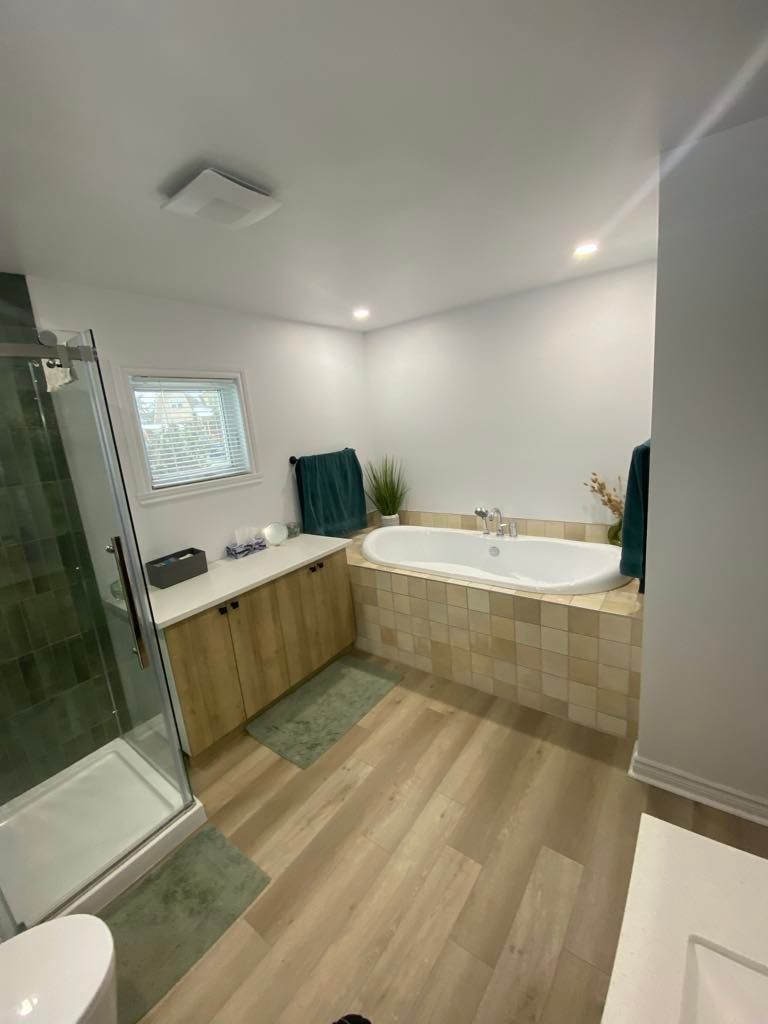 Une salle de bain avec baignoire, douche, lavabo et WC.