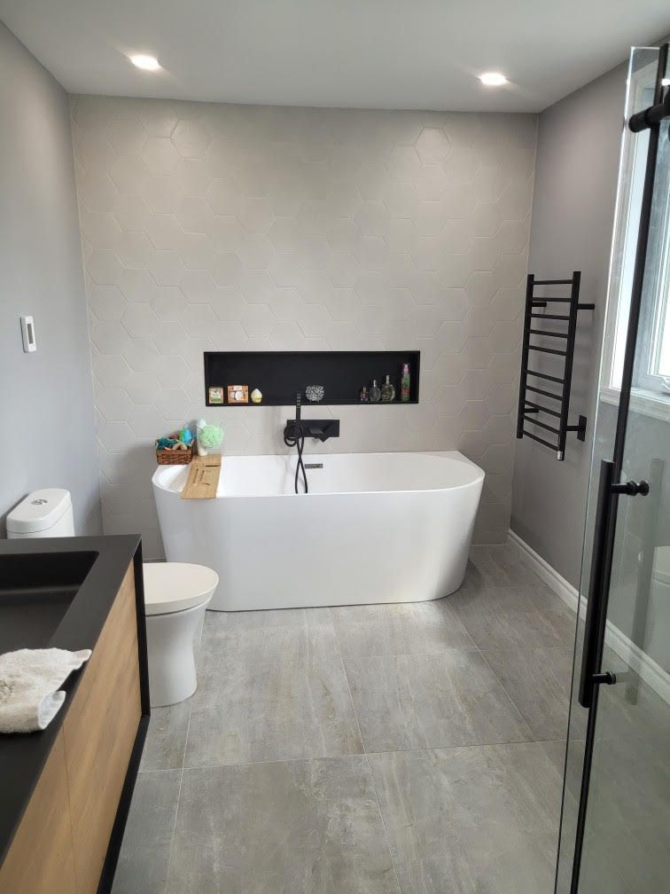 Une salle de bain avec baignoire, WC, lavabo et douche.