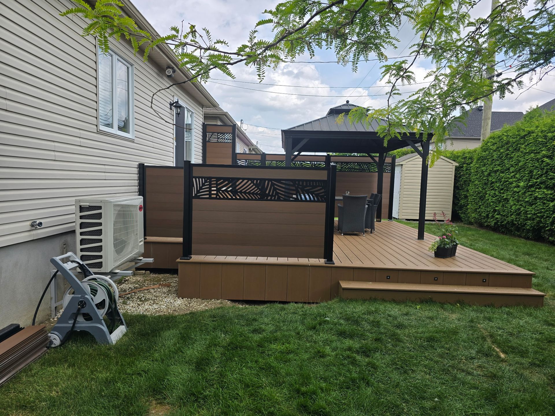 Une terrasse en bois avec un gazebo dans l'arrière-cour d'une maison.