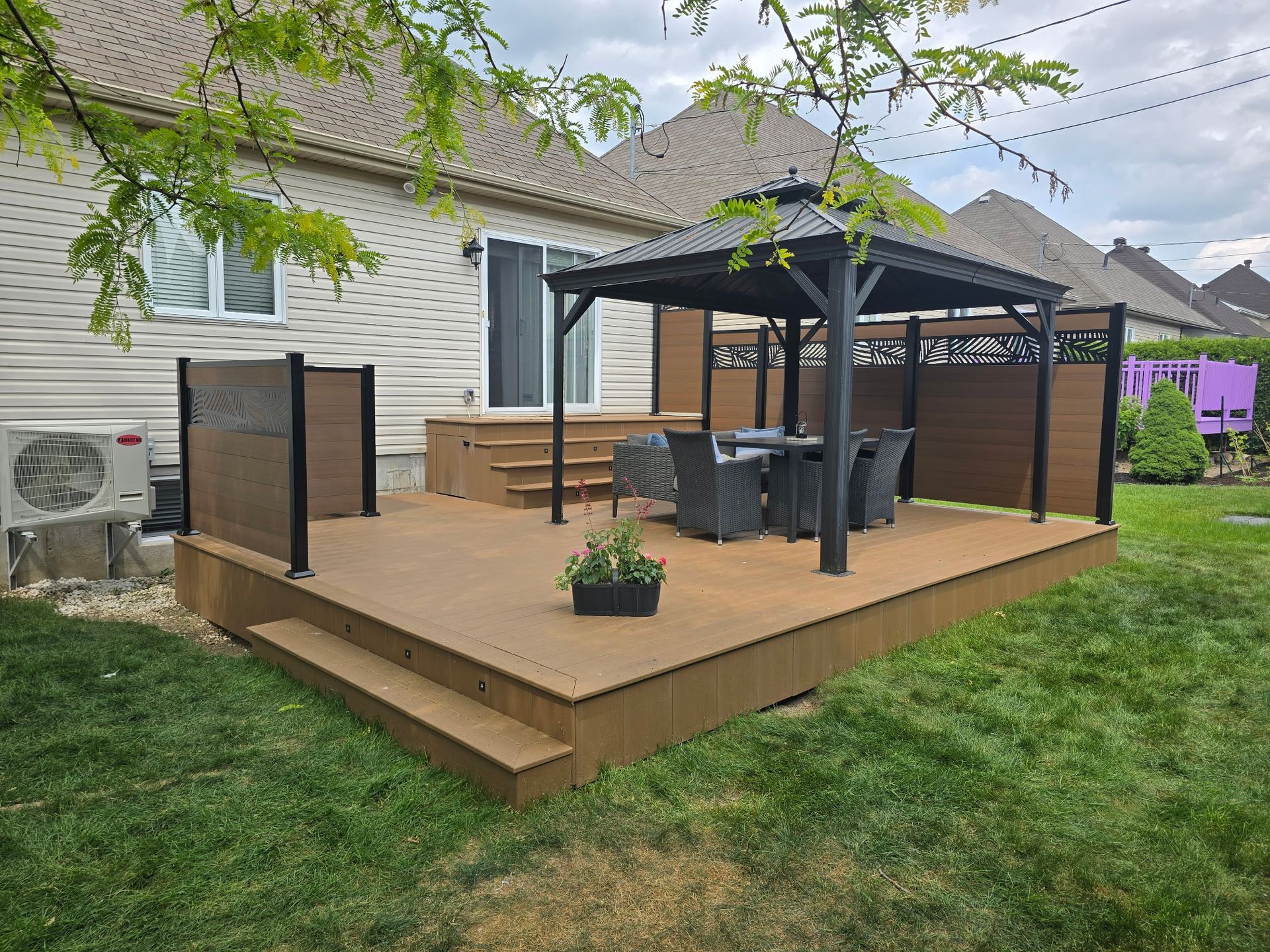Une terrasse en bois avec un gazebo dans l'arrière-cour d'une maison.
