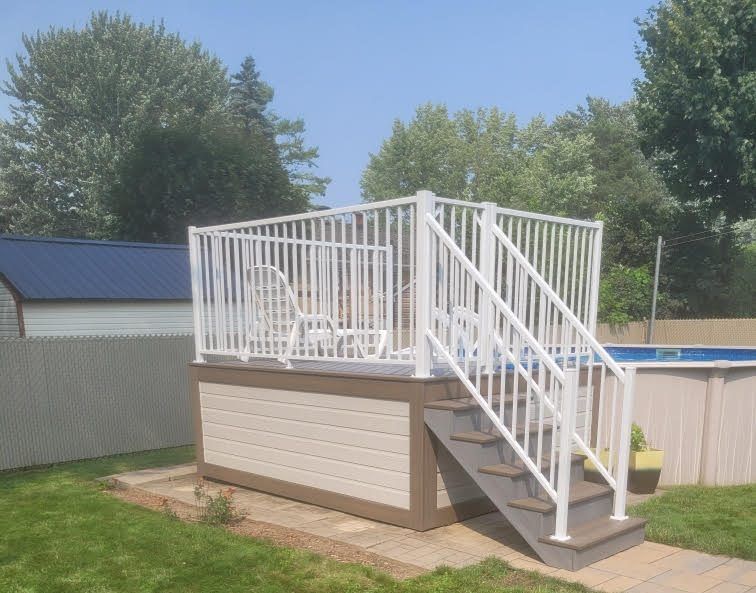 Une terrasse avec des escaliers menant à une piscine dans une cour arrière.