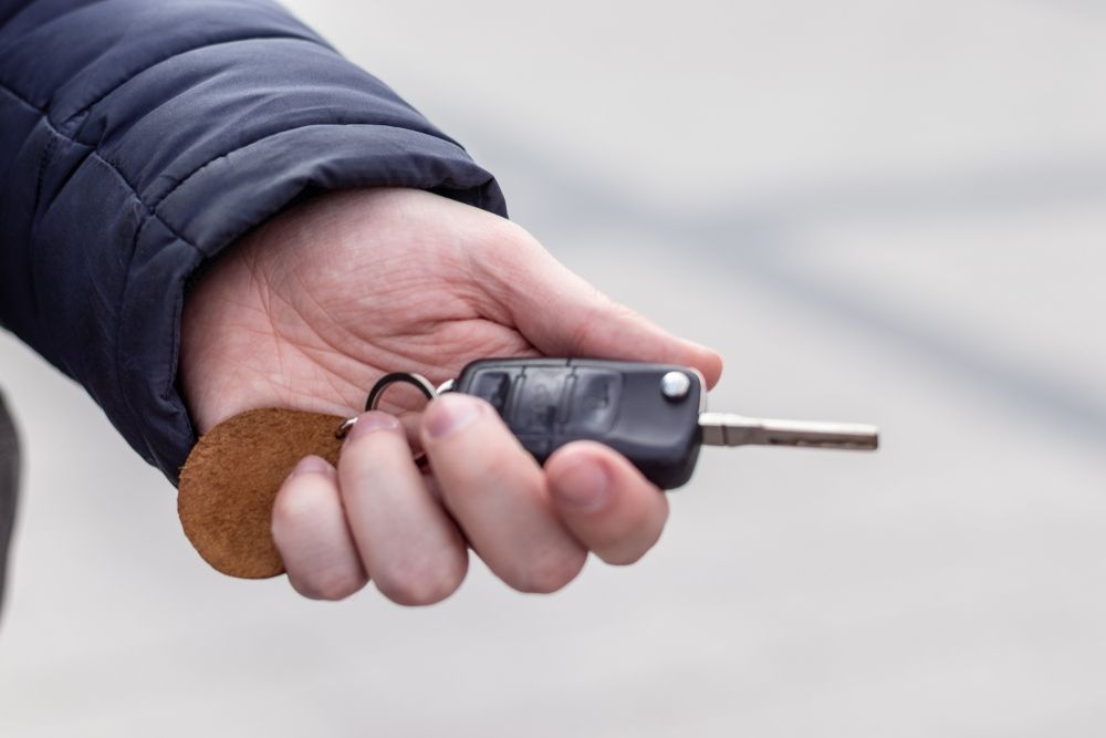 A Person Is Holding A Car Key In Their Hand — JA Toft & Co In Bundaberg Central, QLD
