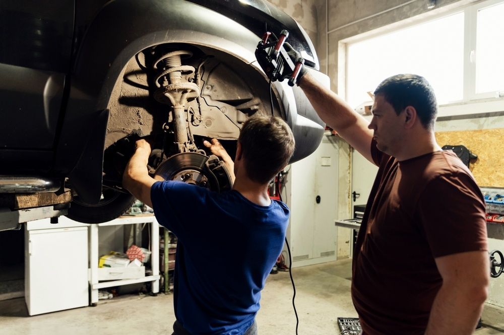 Two Men Are Working On A Car In A Garage — JA Toft & Co In Bundaberg Central, QLD