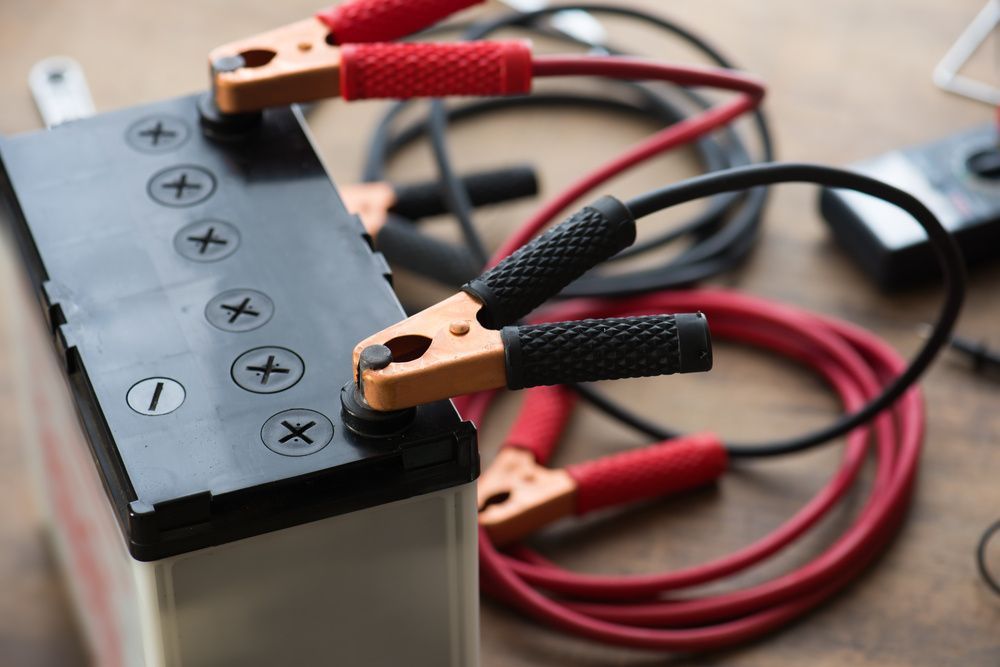 A Close Up Of A Battery With Jumper Cables Attached To It — JA Toft & Co In Bundaberg Central, QLD