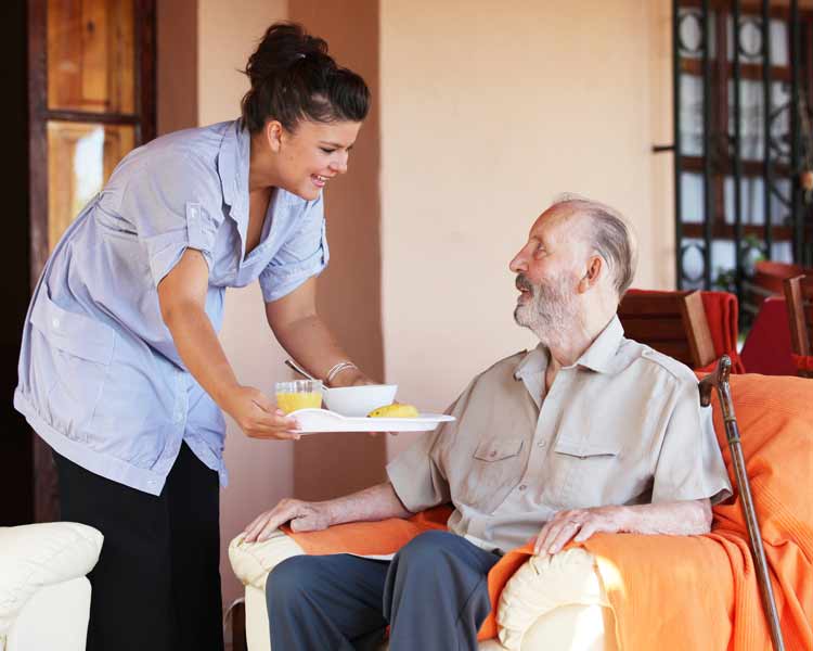 Nurse bringing food to senior man