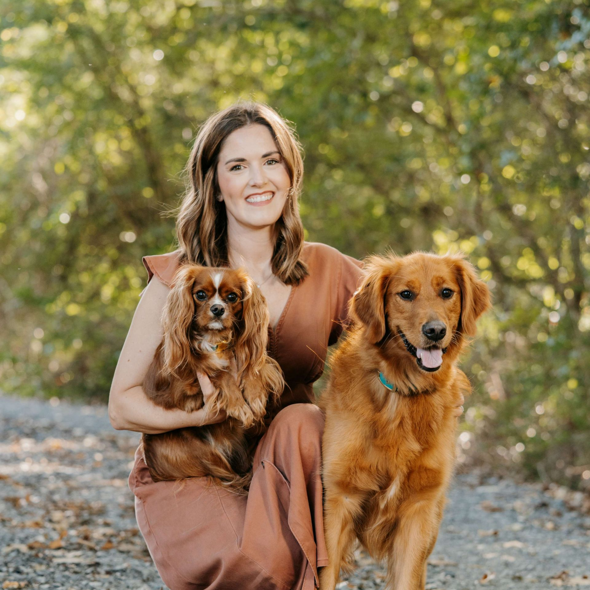 Dr, Grigsby with two dogs outdoors; Cavalier King Charles Spaniel, Golden Retriever.