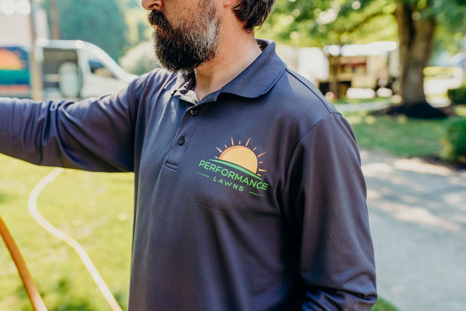 Man in navy polo shirt with company logo, outdoors.
