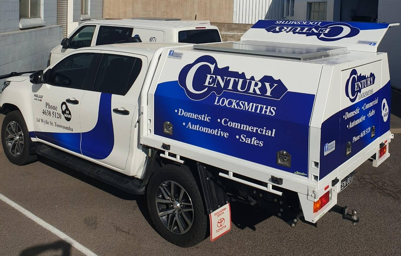 White Century Locksmiths Truck With Blue Logo, Parked Outside a Building — Century Locksmiths in Warwick, QLD