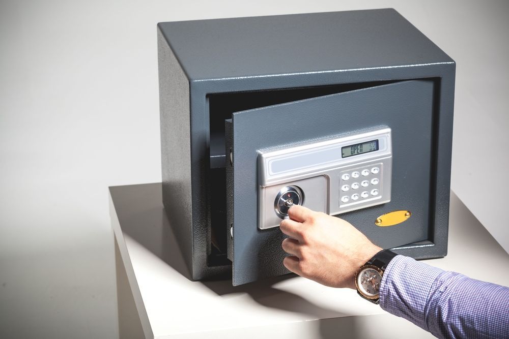 A Person Is Opening a Safe with A Key — Century Locksmiths In Highfields, QLD
