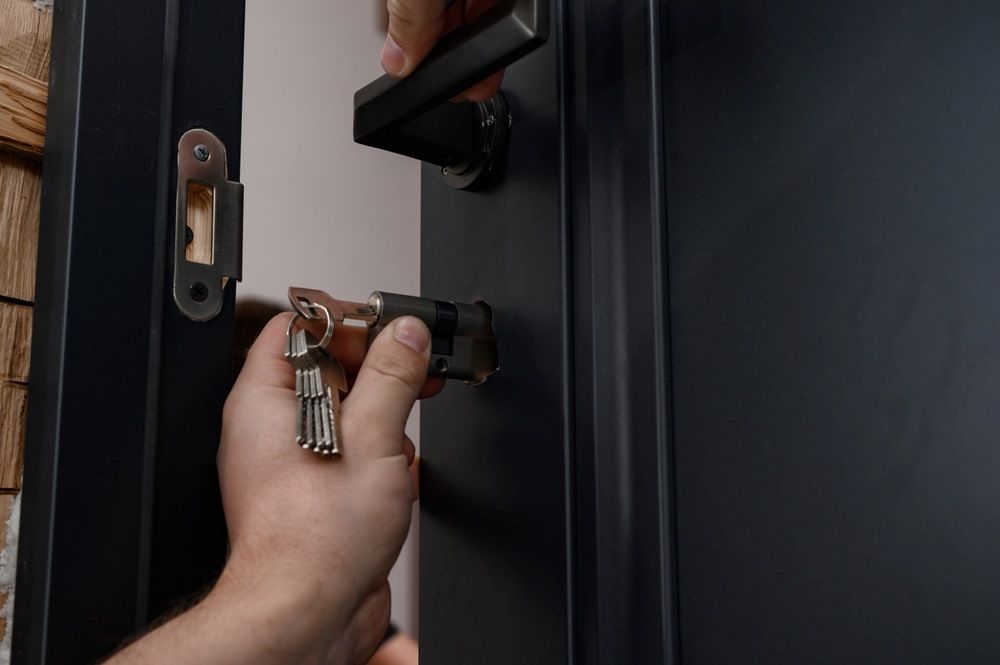 A Person Is Opening a Door with A Key — Century Locksmiths In Pittsworth, QLD