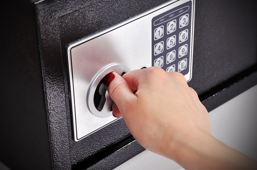 A Person Is Opening a Safe with A Key — Century Locksmiths In Pittsworth, QLD