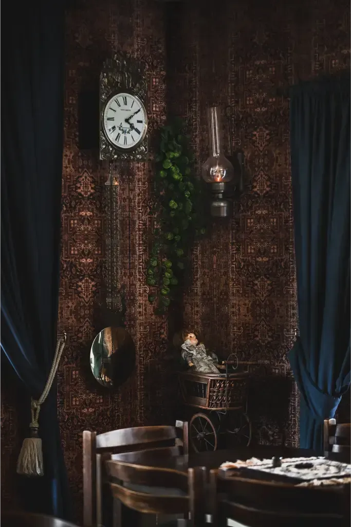 Een kamer met een tafel, stoelen en een klok aan de muur.