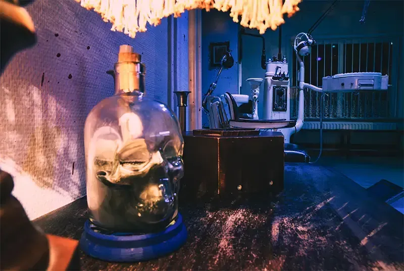 Een fles met daarin een lampje staat op een tafel in een donkere kamer.