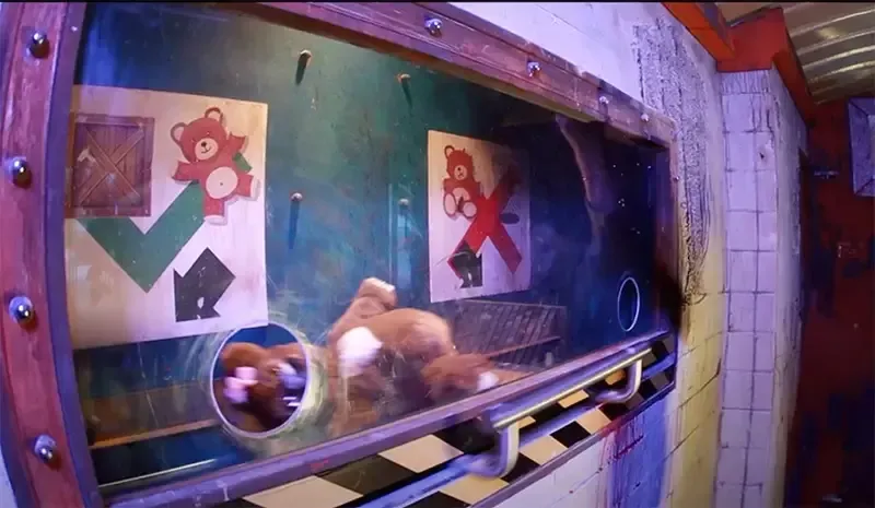 Een teddybeer zit op een lopende band in een kamer.