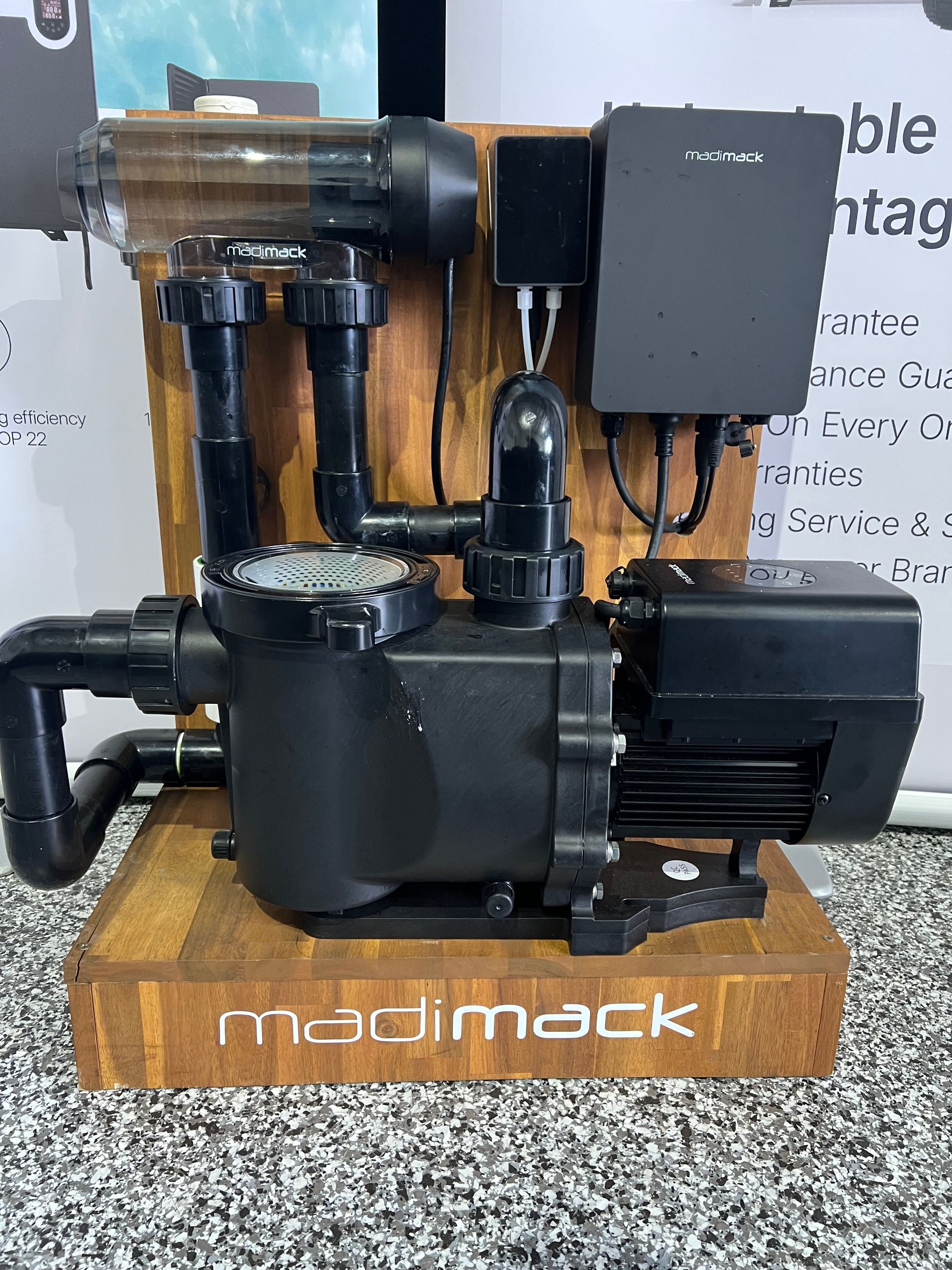 Black coffee machine with grinder on a wooden stand labeled “madimack” on a countertop