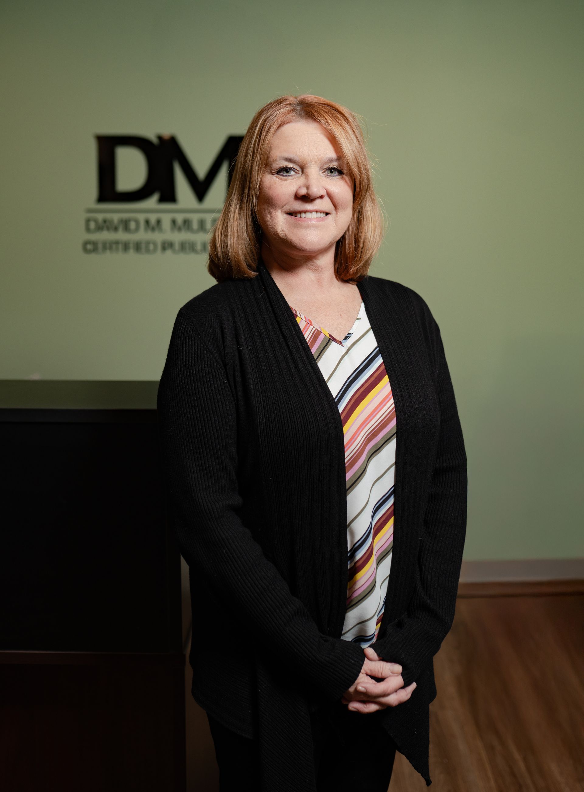 A woman is standing in front of a sign that says dm.