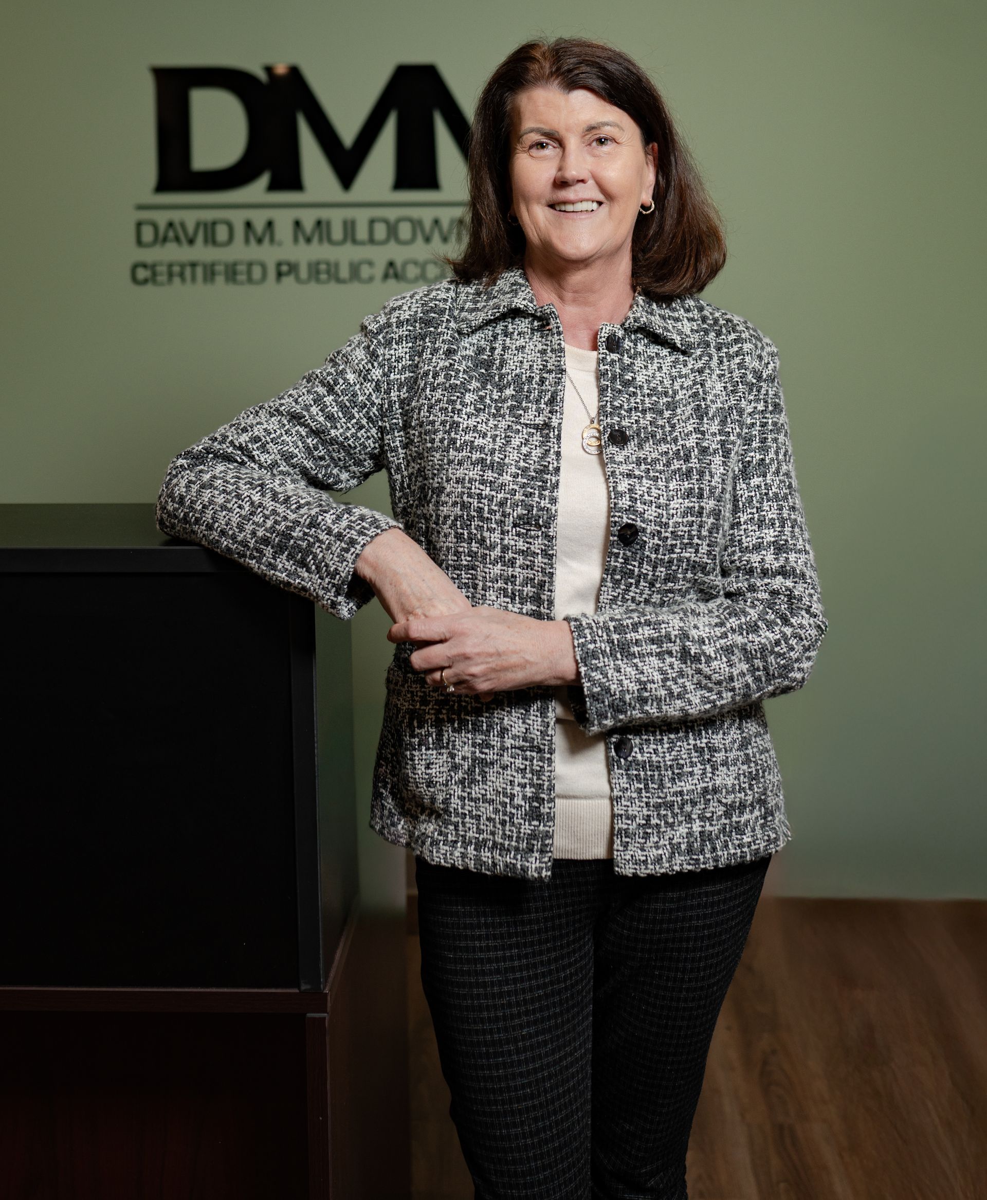 A woman is standing in front of a sign that says dm on it.