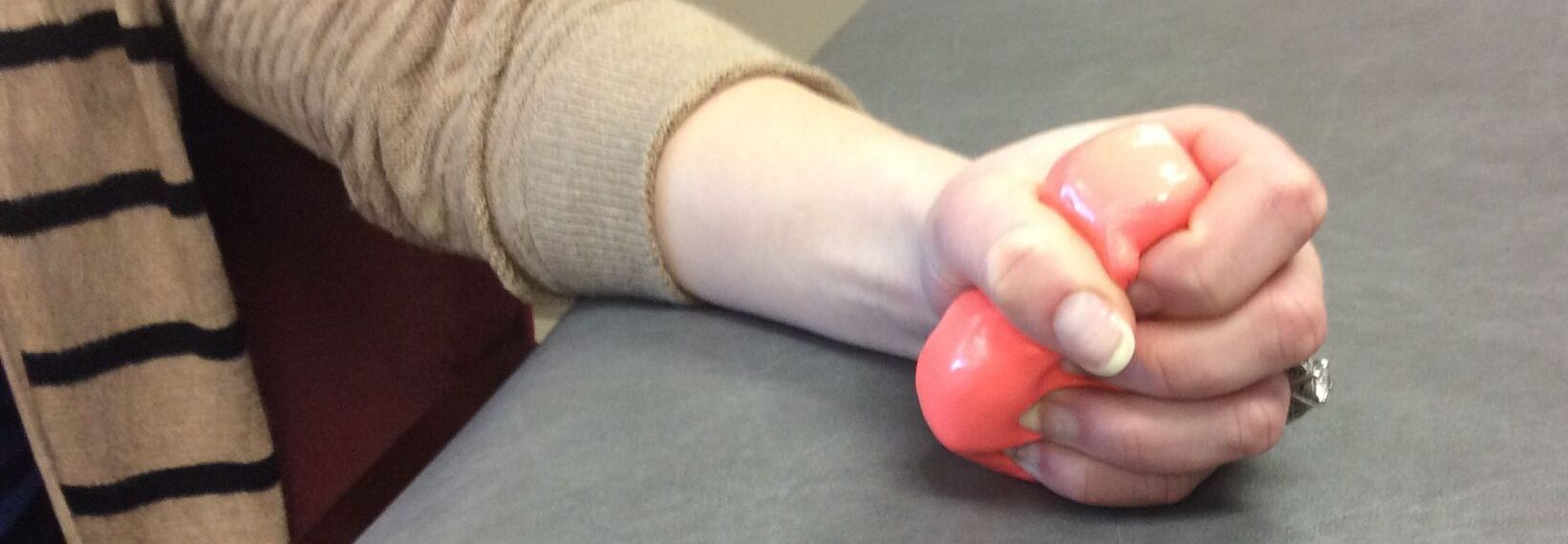 woman squeezes a therapy ball