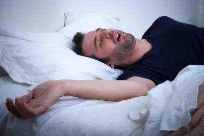 Caucasian man sleeping akwardly.