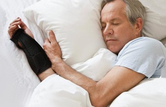man sleeping with a wrist brace
