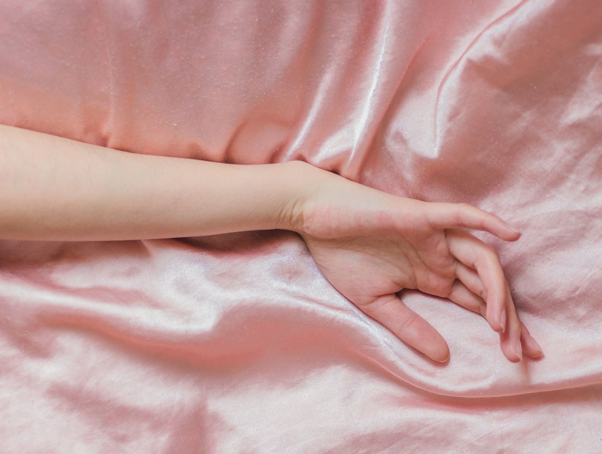a hand resting on satin