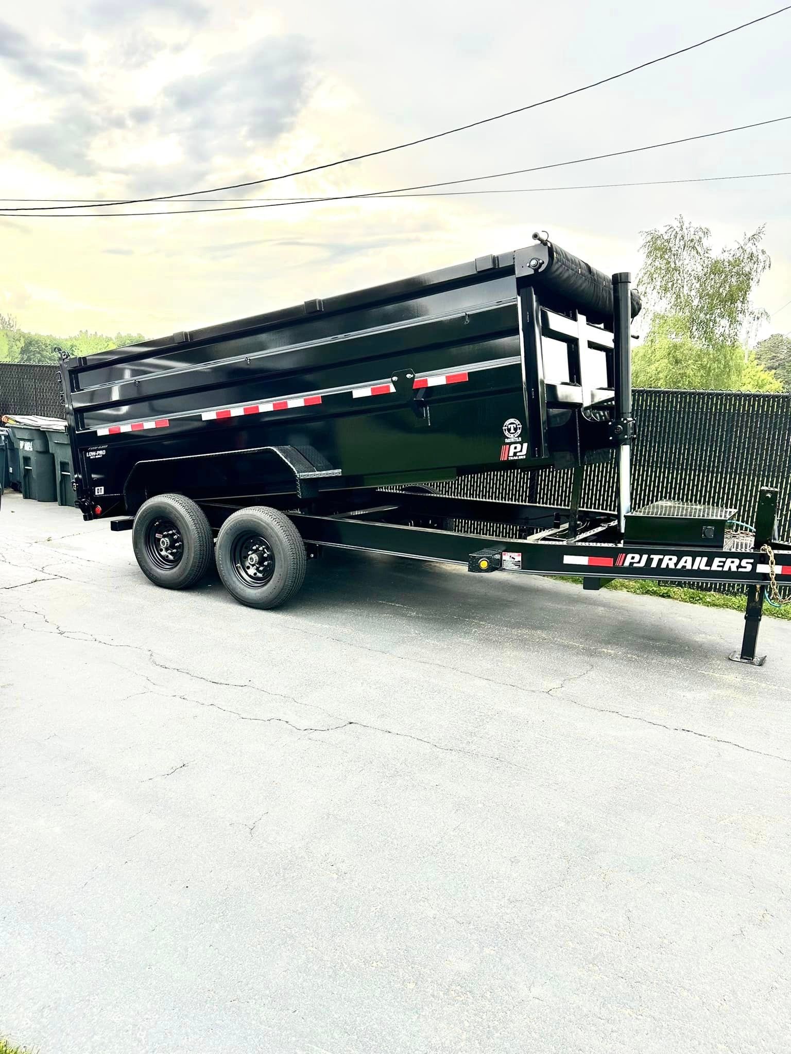 A dump trailer is parked on the side of the road.