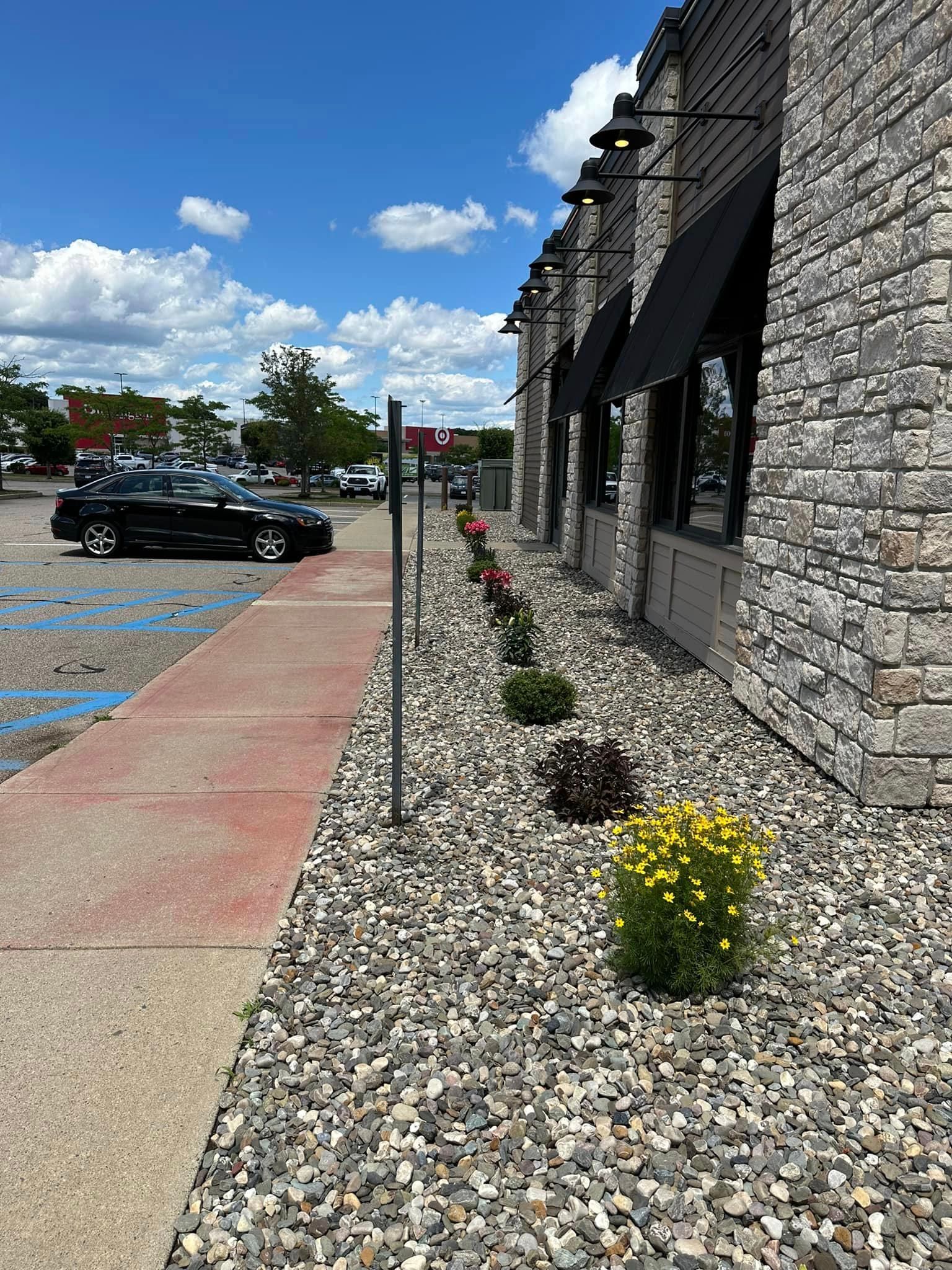 A car is parked in a parking lot in front of a brick building.