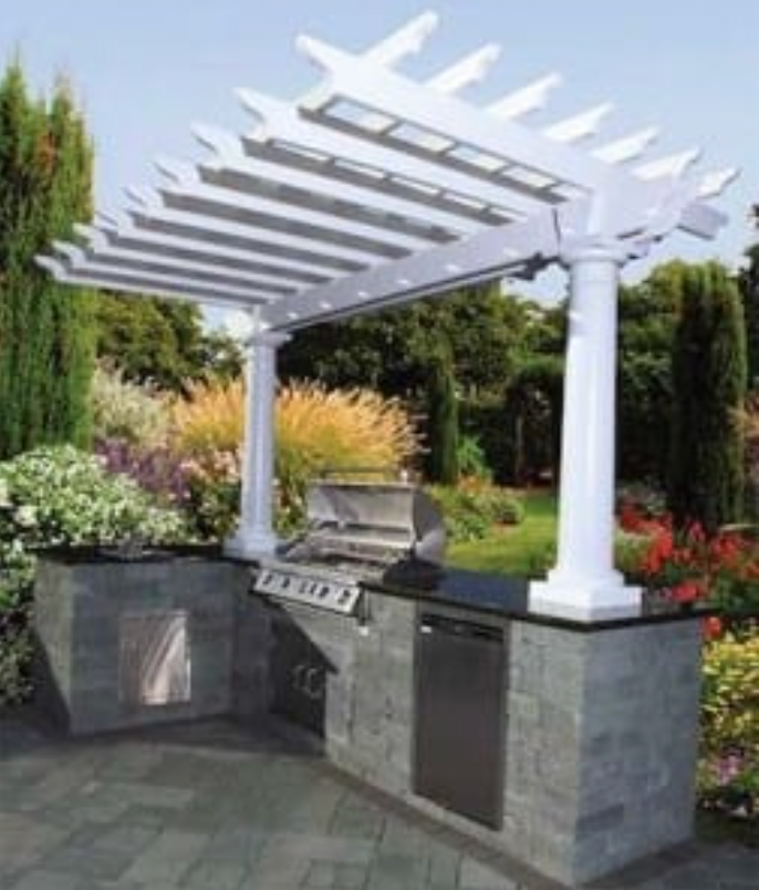 Outdoor kitchen with white pergola, built-in grill, and stone countertops, surrounded by garden.
