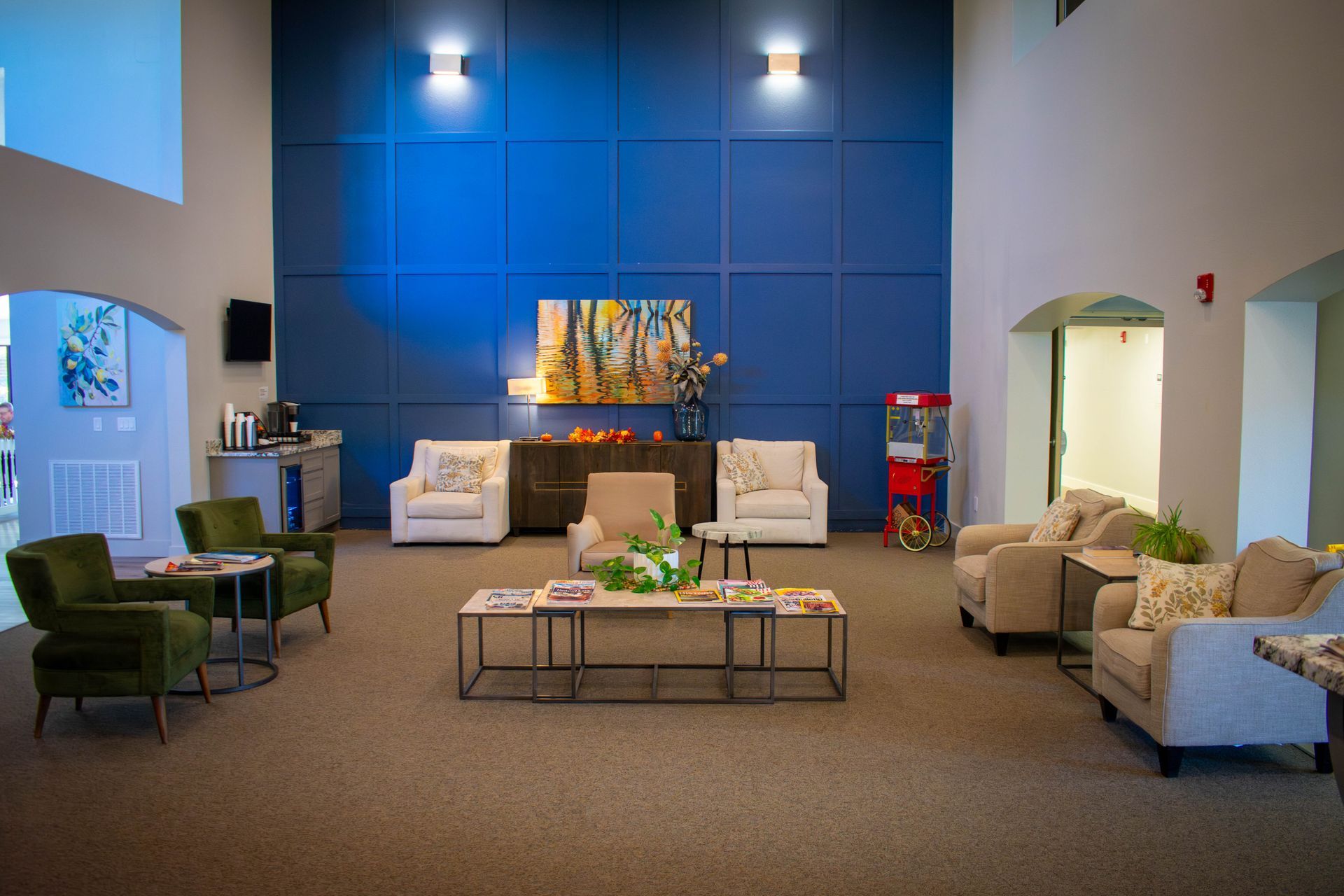 Lobby with blue accent wall, seating areas, artwork, and vending machine.
