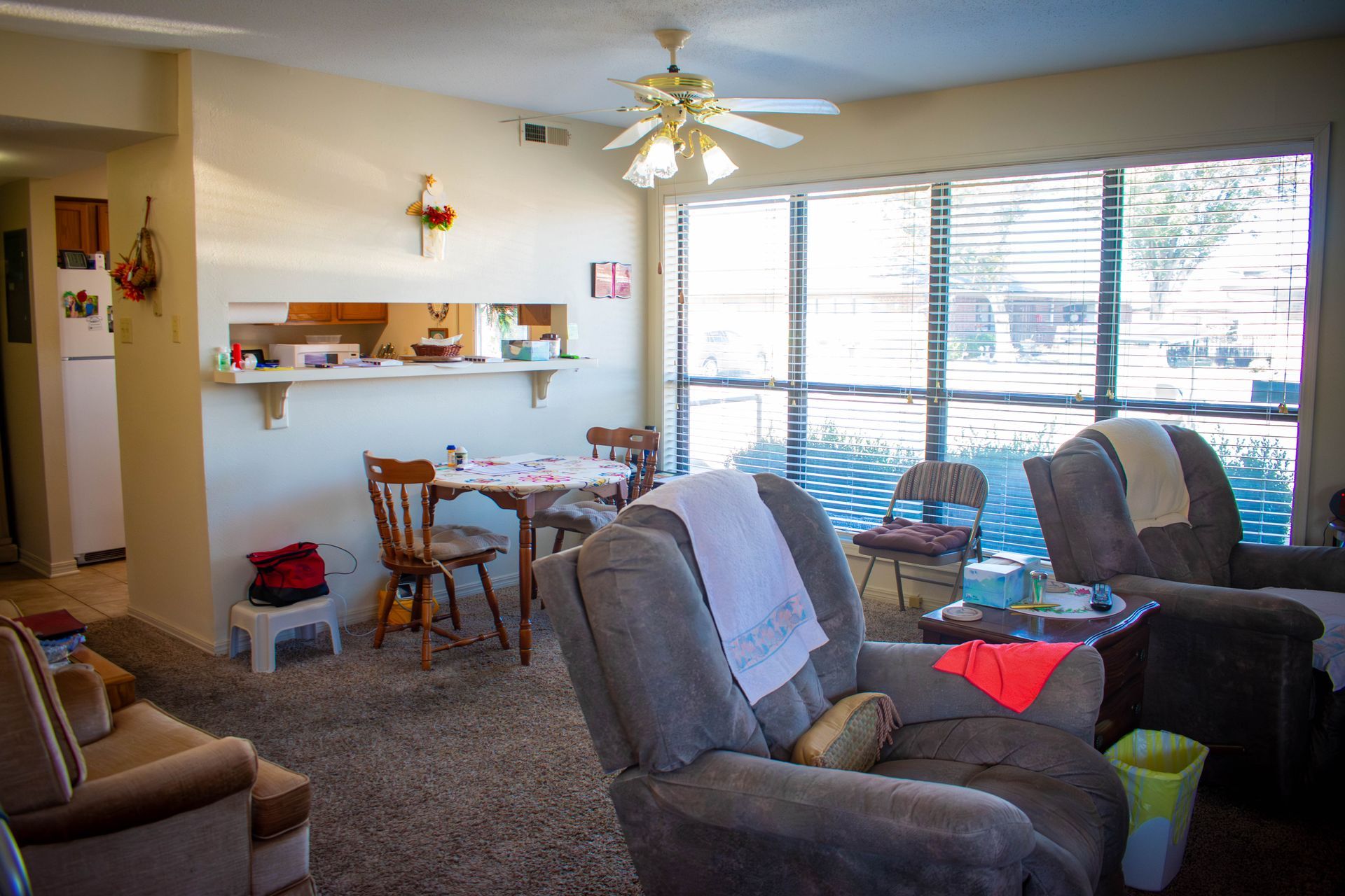 Living room with two recliner chairs, dining table, and large window.