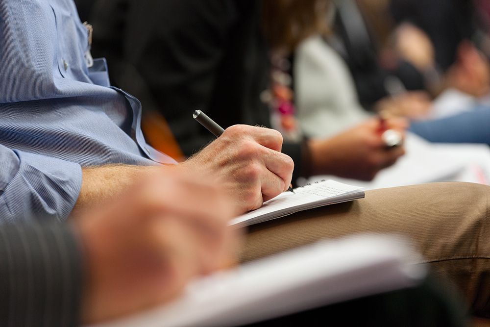 Audience members taking notes during a training session