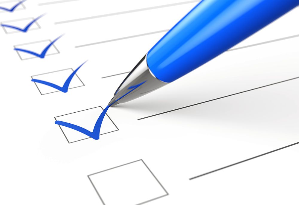 Blue pen marking checks in boxes from a checklist