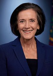 Keynote Presenter Name Studio headshot of a smiling woman in a blue blazer against a dark blue background