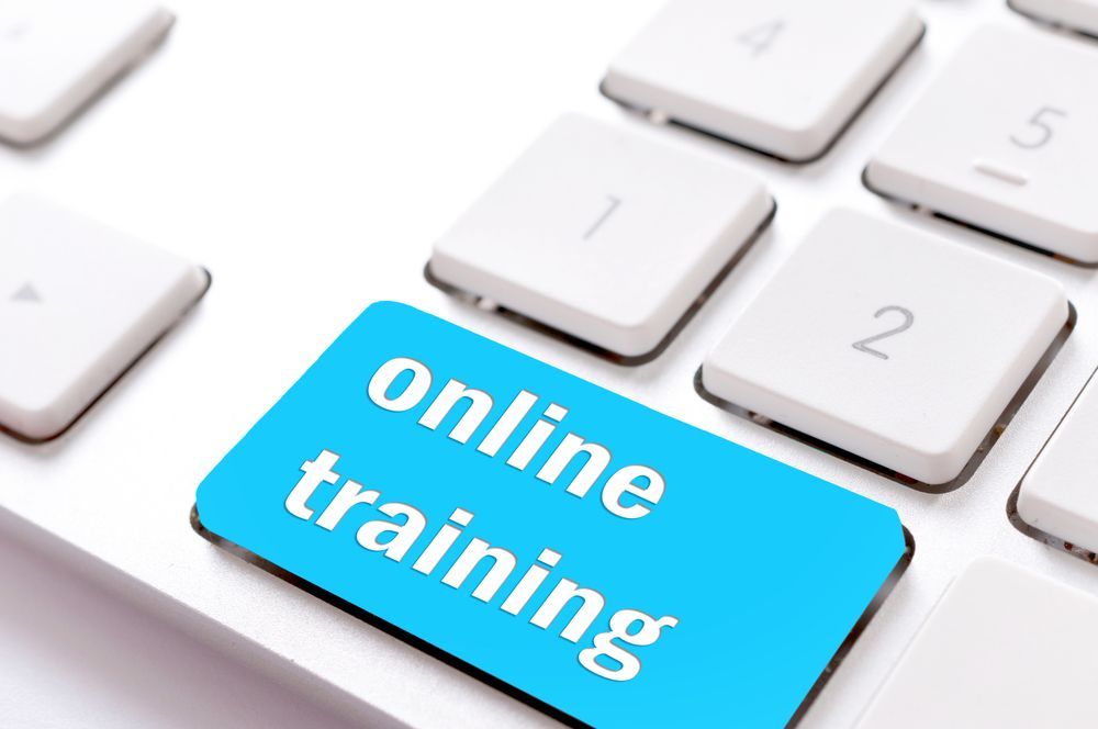 Blue key labeled “online training” on a white computer keyboard