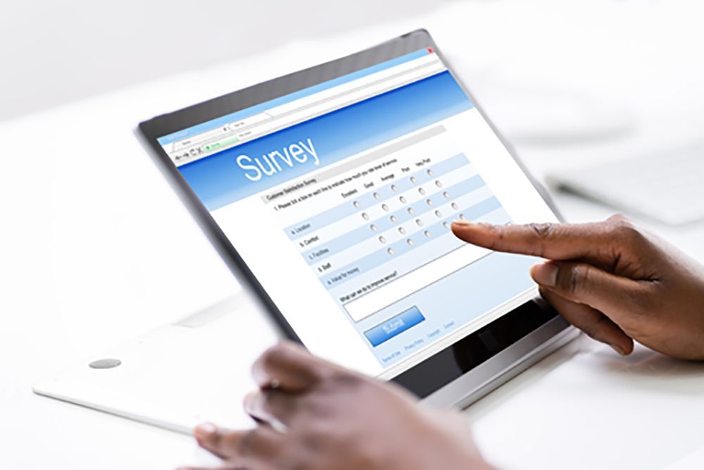 Person filling out a survey on their computer tablet