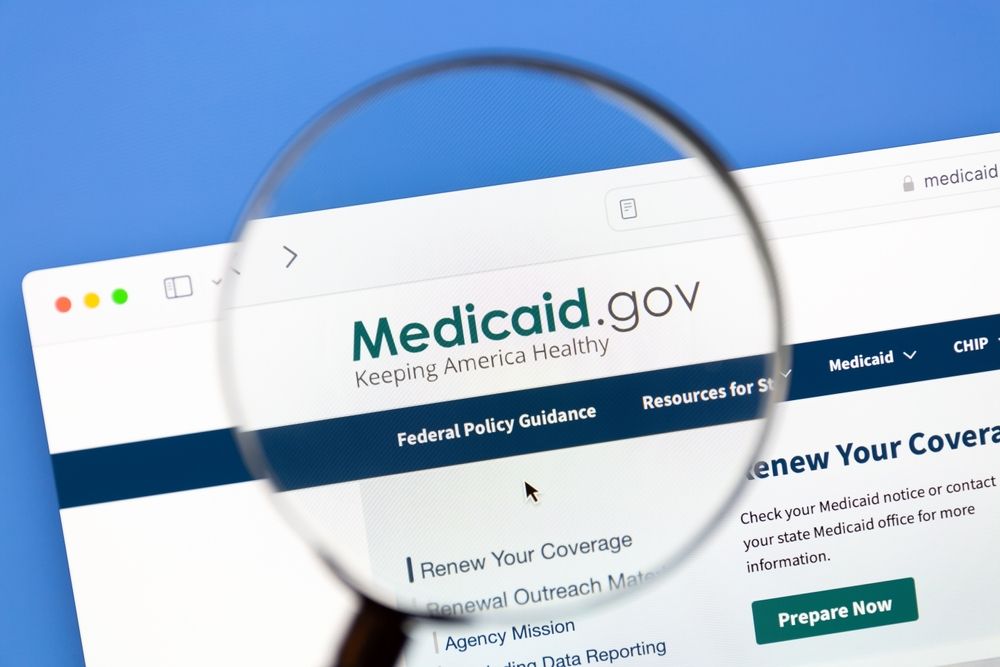 Magnifying glass zooming in on Medicaid.gov website