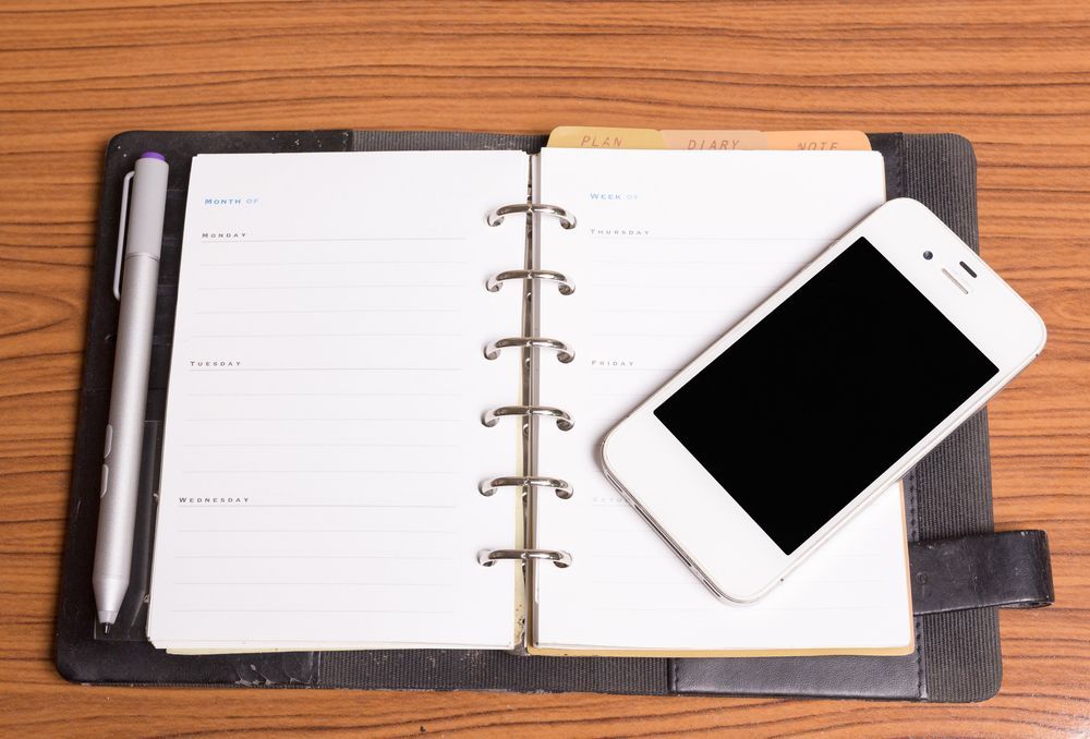 Agenda book and cell phone on desk