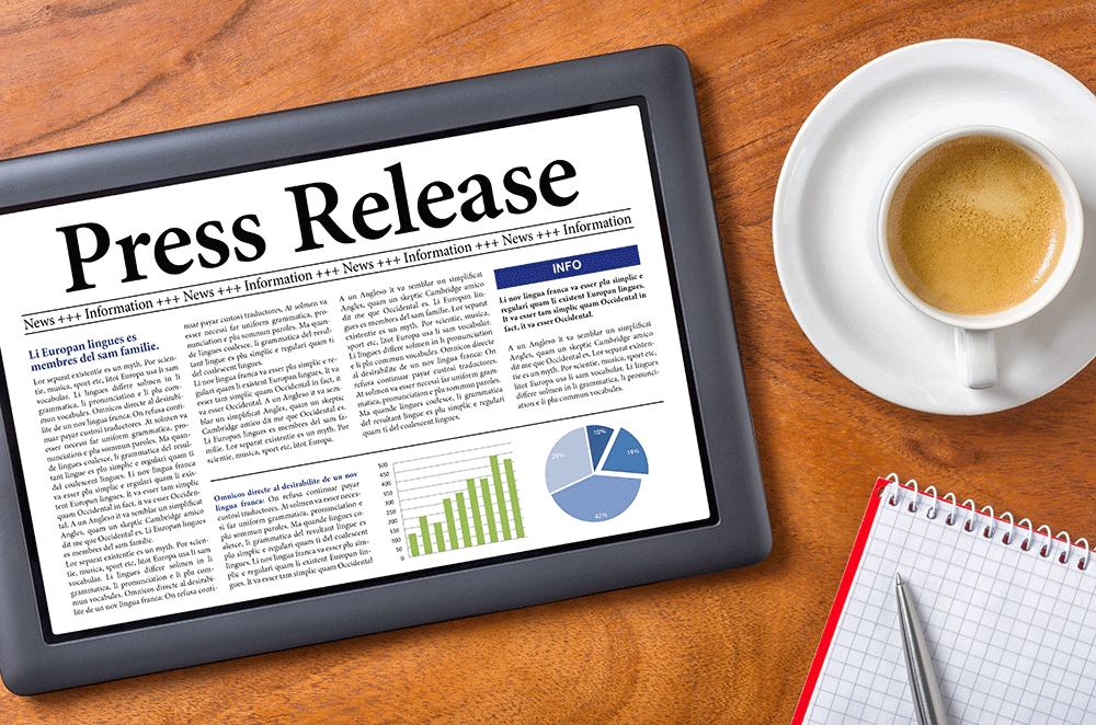 Press Release text on electronic tablet next to cup of coffee