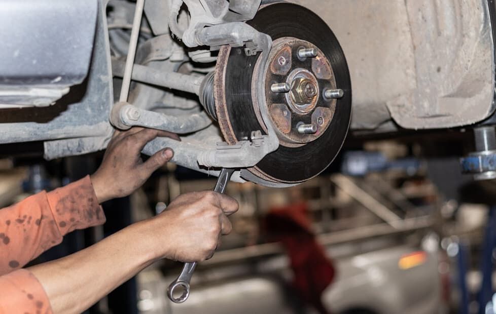 A Man Is Working On A Car With A Wrench — North Queensland Diesel Tune In Kirwan, QLD